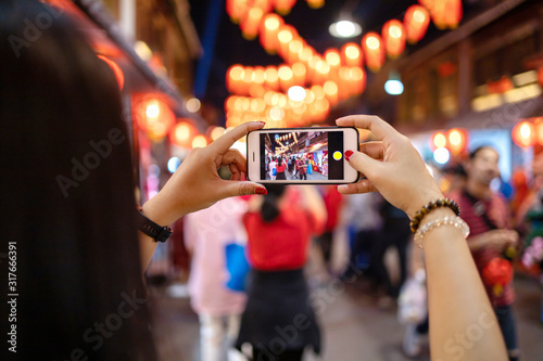 Women use mobile phones to take pictures of festivals.