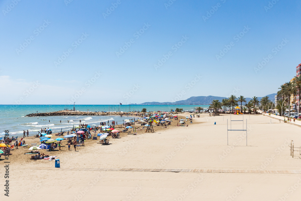 Torrenostra beach, Spain. Beautiful beach resort on the mediterranean coast near Valencia. Sunny summer day, blue sky & crowded beach. 