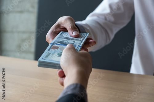 The businessman receiving bribe money from another businessman at the office