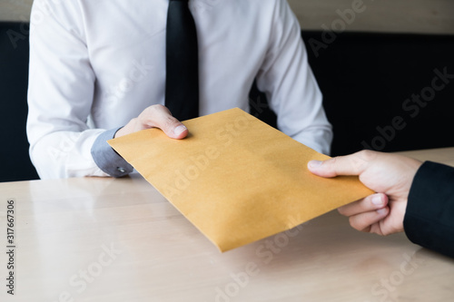Canvas Print The businessman receiving bribe money in a brown envelope form another man at th