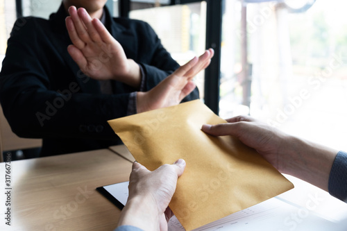 The businessmen refusing accept bribes in a brown envelope at the office. photo