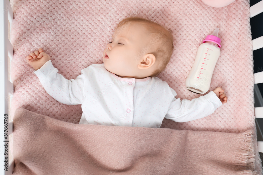 Sleeping baby with bottle of milk in crib Stock Photo Adobe Stock