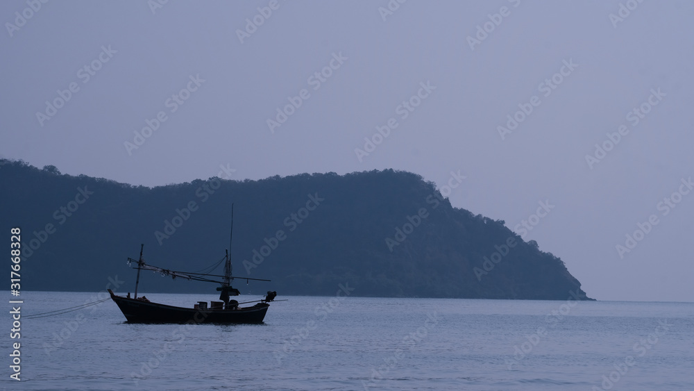 fishing boat in the sea, on a morning time, beauty nature sea background. wide view of a cliff in the distance fishing boat in the sea, on a morning time, beauty nature sea background. wide view of a cliff in the distance