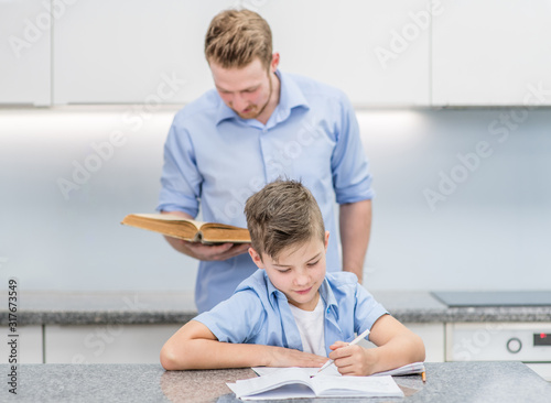 Vászonkép Father and son do school homework at home