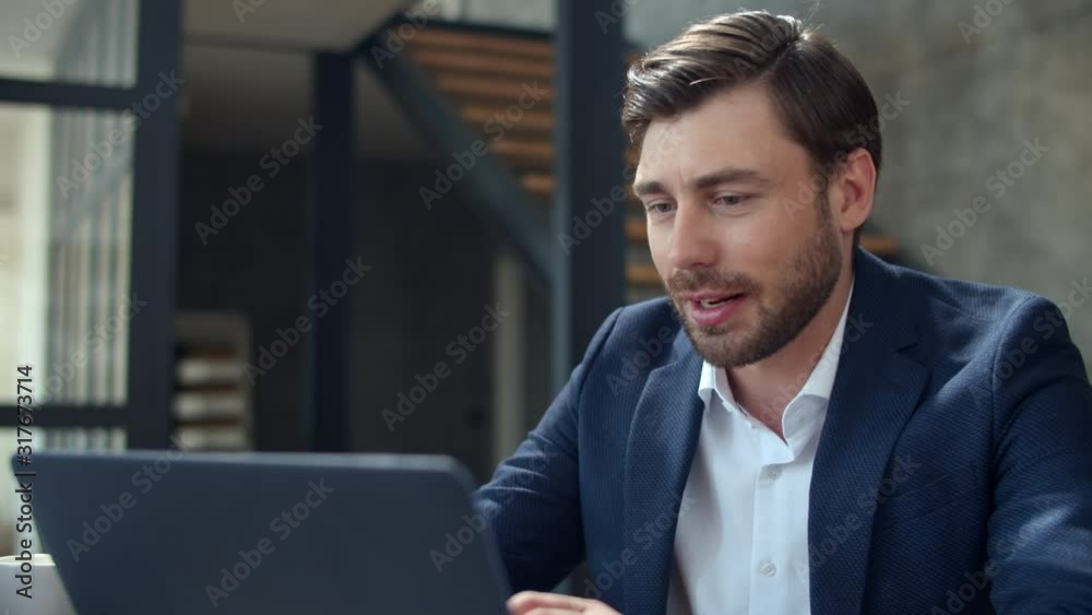 Smiling businessman working with laptop computer and papers in office. Smiling businessman working with laptop computer and papers in office.