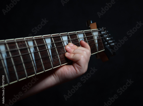 Children's hand close up learning guitar playing