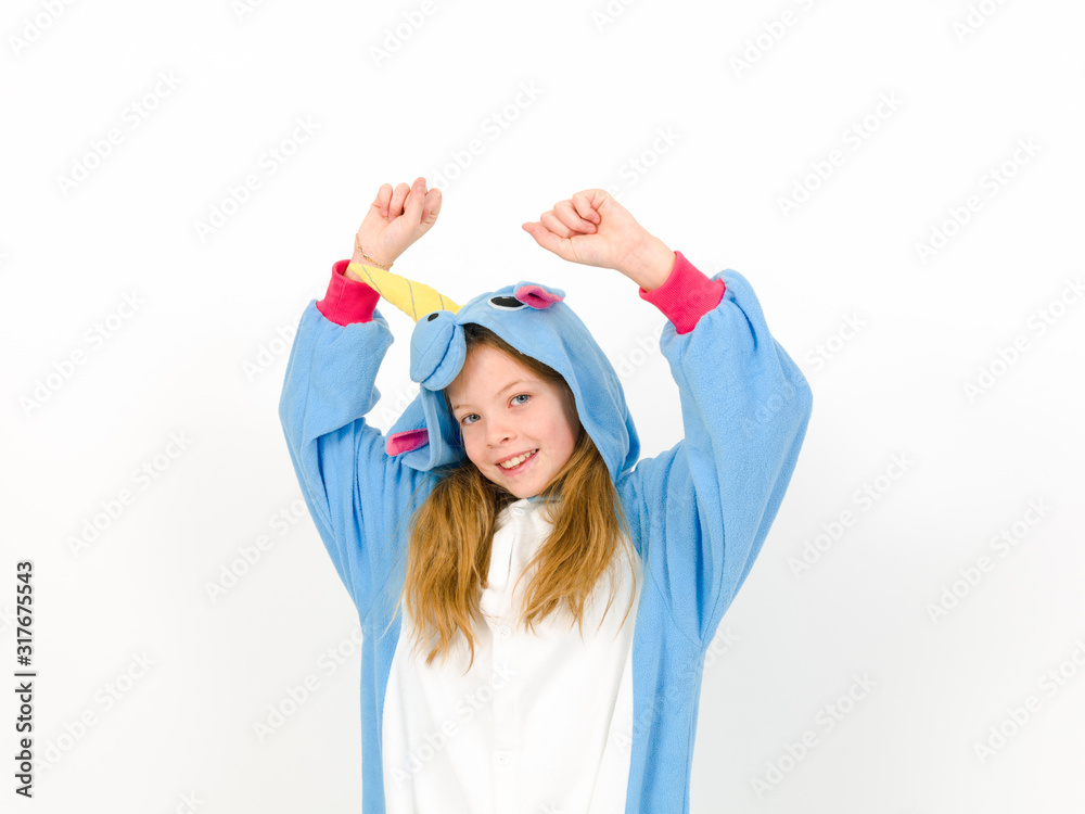 pretty blonde girl with cozy blue unicorn costume is posing in the studio in front of white wall and is happy pretty blonde girl with cozy blue unicorn costume is posing in the studio in front of white wall and is happy