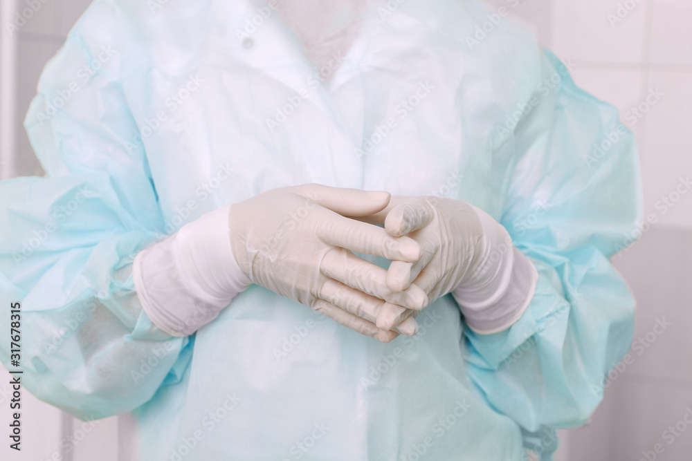 Fototapeta premium Doctor ophthalmologist surgeon is getting ready for microsurgery operation. The medical latex gloves professional safety equipment concept