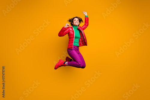 Full length photo of cheerful cute sweet girl jump win season lucky discounts raise fists wear red boots trendy green sweater clothes isolated over yellow shine color background