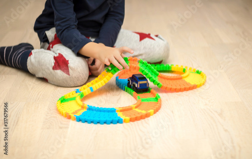Small boy playing with car toy at home.