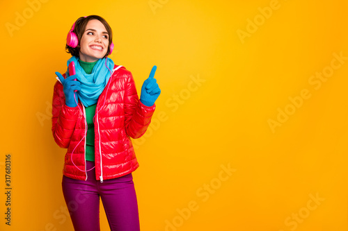 Photo of pretty lady hold smart phone listen earphones dancing party chilling mood wear casual red coat blue scarf gloves trousers isolated yellow color background