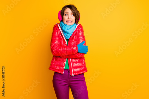 Photo of pretty traveler lady cold frosty weather trip new country shaking teeth wear stylish casual short red overcoat blue scarf gloves earmuffs pants isolated yellow color background