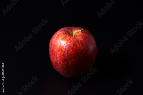 Red apple isolated on a black background.