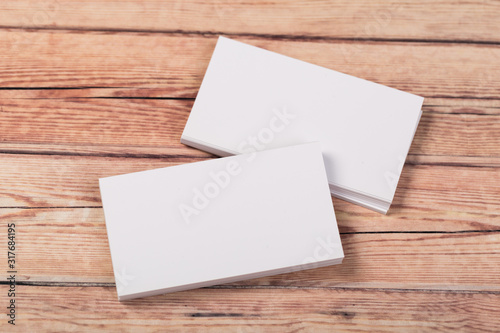 Photo of empty business cards on a light natural wooden background .. Template for identifier.
