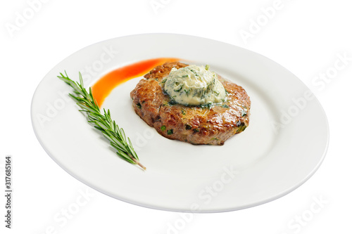Steak with green butter, sauce and rosemary on a plate isolated on a white background