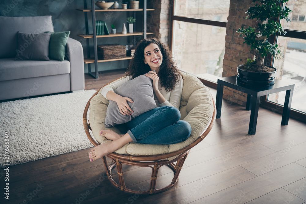 Obraz premium Nice attractive lovely charming cute sweet cheerful cheery peaceful wavy-haired girl sitting in armchair in modern loft industrial brick style interior living-room