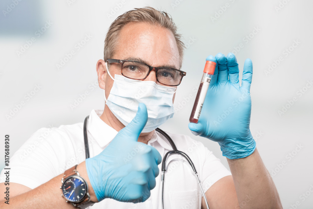 doctor mit medical face mask and medical gloves shows a blood probe and ...