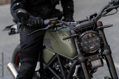 The front wheel of the motorcycle with a drum brake and a cable to it is the front fork with a shock absorber and a spring. focus on a headlamp. Retro motorcycle with headlight.
