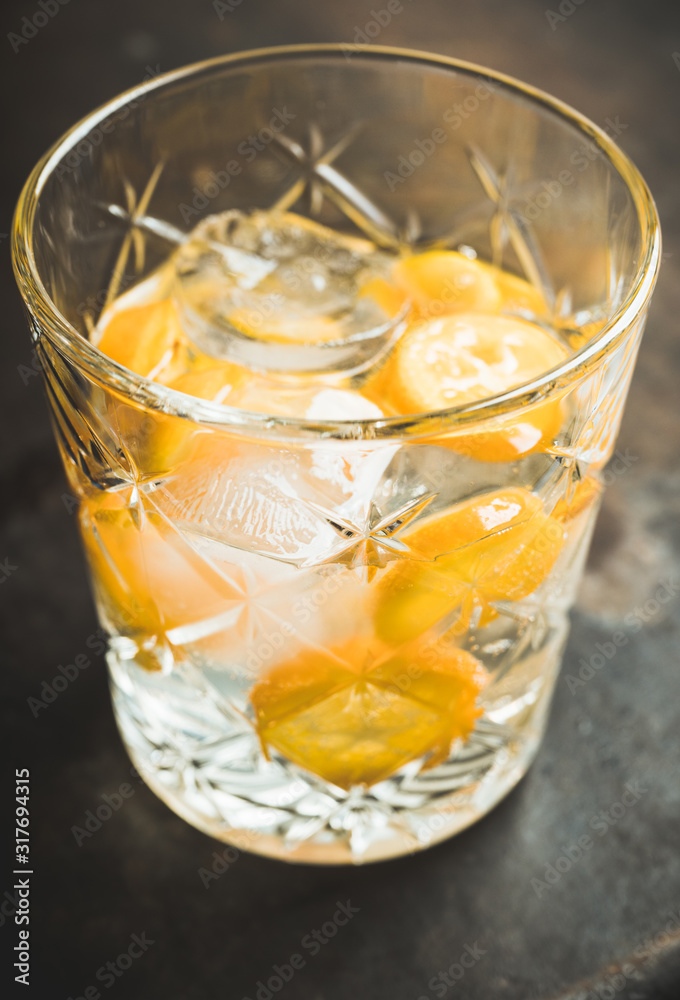 Old fahioned beverage with strong alcohol and kumquats on rustic background. Selective focus. Shallow depth of field. Old fahioned beverage with strong alcohol and kumquats on rustic background. Selective focus. Shallow depth of field.
