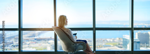 Businesswoman sitting in an office looking out at the city