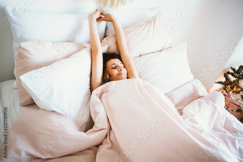 Φωτογραφία Woman stretching in bed after wake up