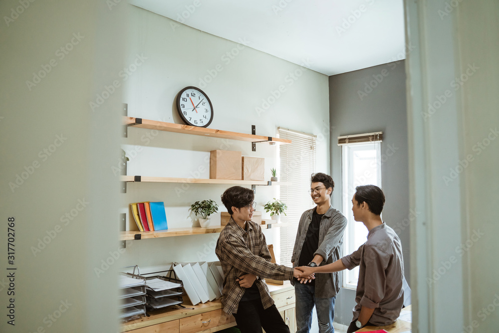 three young Asian entrepreneur work together in agreement at planning with unite gesture at work three young Asian entrepreneur work together in agreement at planning with unite gesture at work