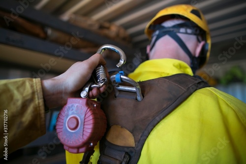 Φωτογραφία Male construction worker hand clipping locking carabiner which connecting with s