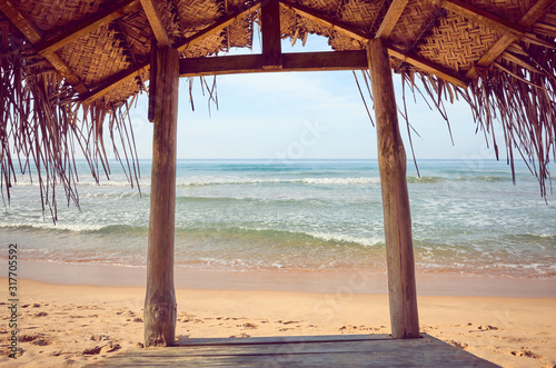 Fototapeta Naklejka Na Ścianę i Meble -  Tropical beach wooden shade, color toning applied, summer vacation concept.