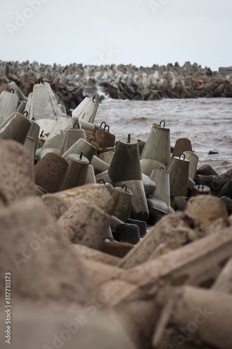 Baltic sea waves hitting stone blocks near path to ship lighthouse. Path located near Ventpils Docks. photo