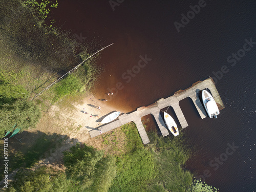 Aerial top down view of blue lake and small boats on the pier. Bird's eye view drone photography. Ruovesi, Finland. photo