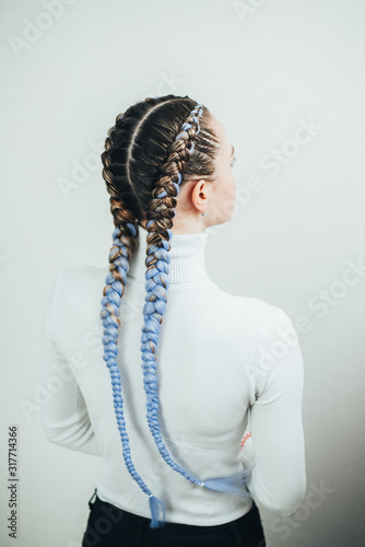 Girl with pigtails, two braids with the addition of artificial material in blue photo