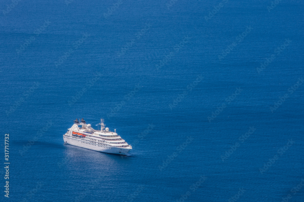  Aerial drone photo of luxury yacht cruising near iconic village of Oia, Santorini island, Cyclades, Greece 