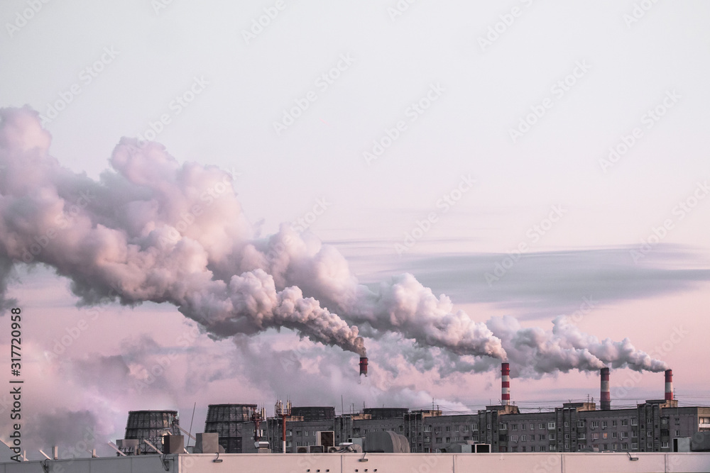 Copy spase with industrial chimneys with heavy smoke causing air pollution as ecological problem on the pink sunset sky background