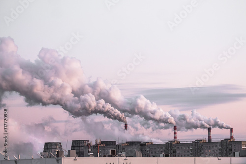 Copy spase with industrial chimneys with heavy smoke causing air pollution as ecological problem on the pink sunset sky background