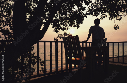 a man looking sunset view on balcony