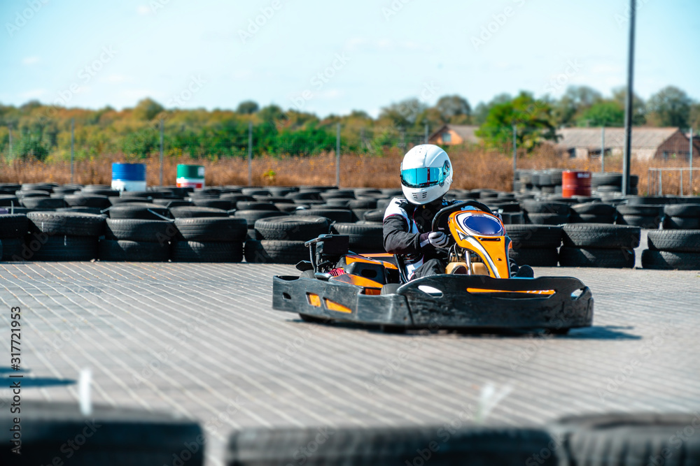 A driver in gear and helmet drives a racing car. In action. Go karts racing, sreet karting, rent. extreme sport. fun entertainment for drivers