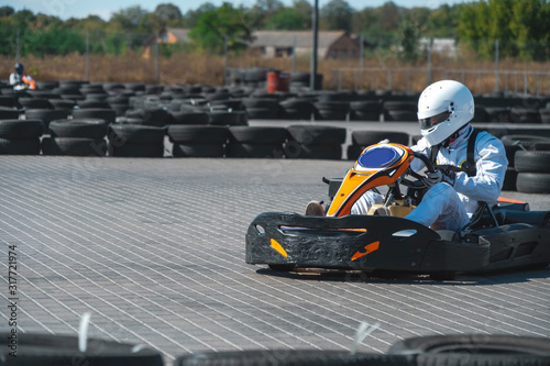 A driver in gear and helmet drives a racing car. In action. Go karts racing, sreet karting, rent. extreme sport. fun entertainment for drivers
