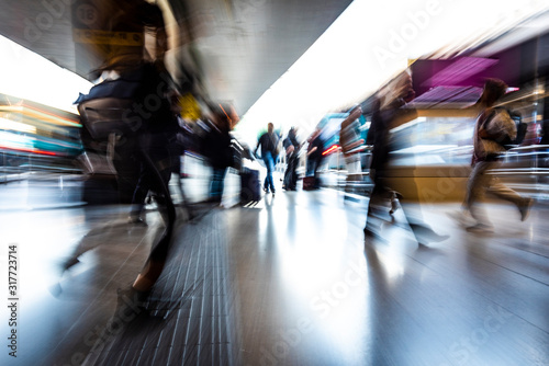 people in the station as they walk fast, blurred photo