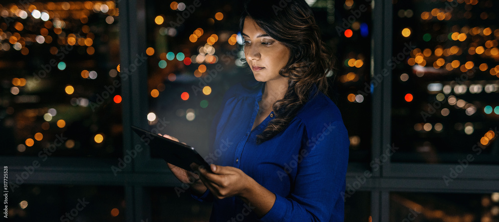 Young businesswoman working online late at night in the office Young businesswoman working online late at night in the office