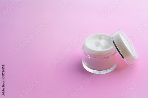 Cream jar with open lid on a pink background,beauty care 