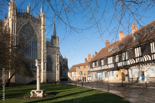 York Misnster yard, an ancient sundial on top of a column, half-timbered houses and the east front of the great cathedral photo