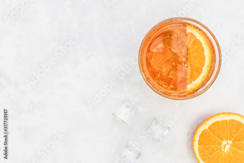 Orange spritz Italian fruit cocktail drink in glass with ice top view on white background