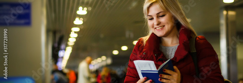 Pretty young woman at the airport with tickets and passports