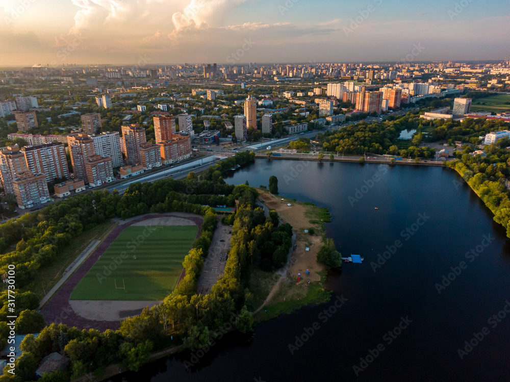 Football stadium on the river in a residential area of the city, in the background houses and a highway. Aerial photography