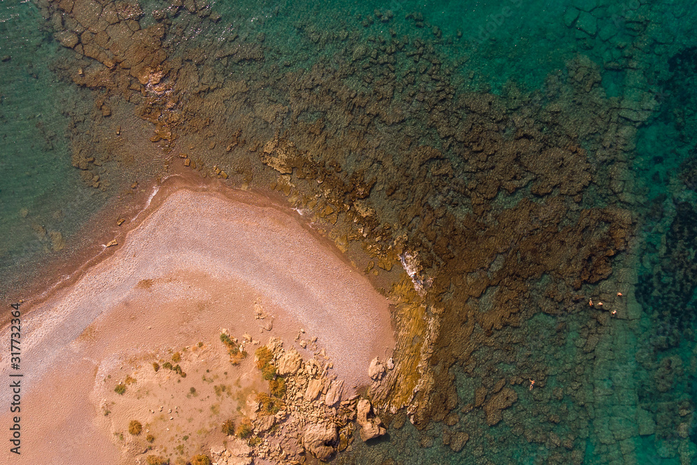 Aerial view from a drone on the view of calm turquoise sea water and rocks. Pattern of sea surface and rocky shore. Rocky coast of the peninsula