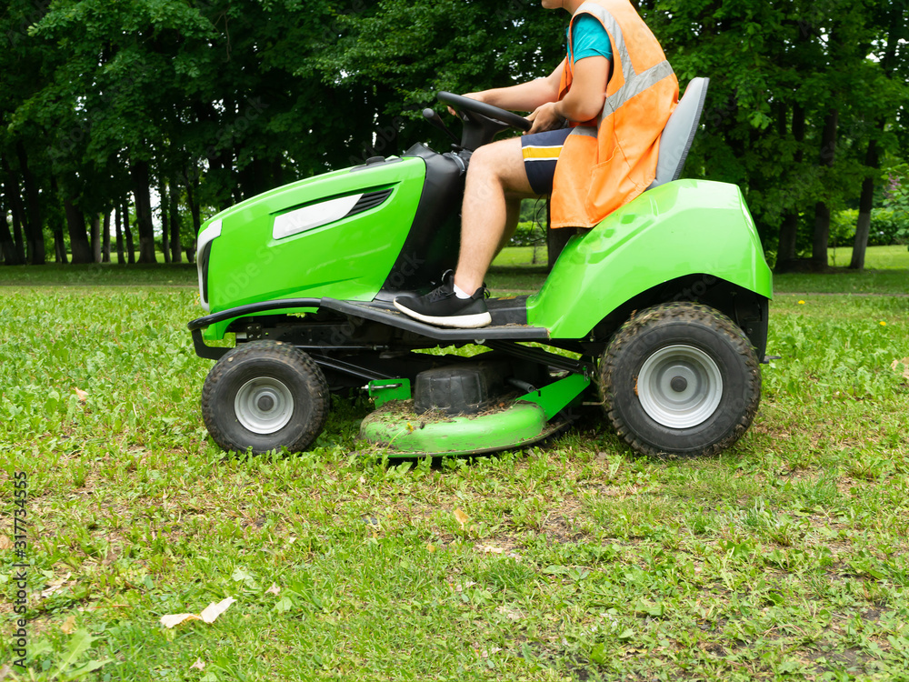 Professional lawn mower cuts the grass. Mowing in parks and residential areas. Professional lawn mower cuts the grass. Mowing in parks and residential areas.
