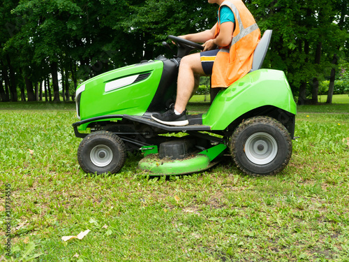 Professional lawn mower cuts the grass. Mowing in parks and residential areas.