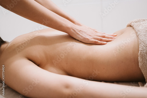 young caucasian Woman receiving back massage from physiotherapist female in clinic. Physiotherapy concept