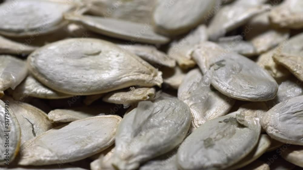 Unpeeled pumpkin seeds in rotation. Macro video. Unpeeled pumpkin seeds in rotation. Macro video.