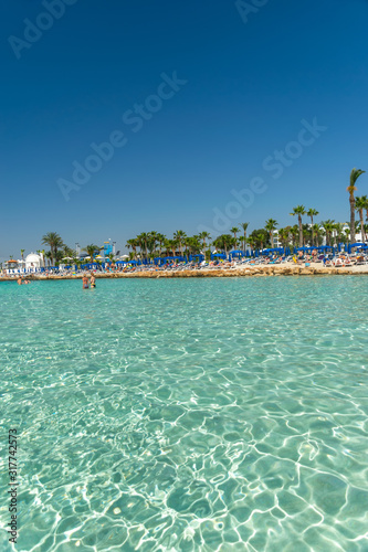 CYPRUS, NISSI BEACH - MAY 12/2018: Tourists relax and swim on one of the most popular beaches on the island.